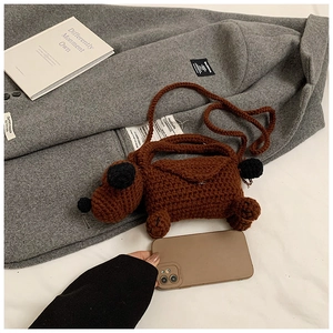 Detail view of the brown crochet dog bag showing size comparison with a smartphone