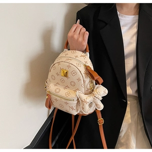Detail view of mini printed backpack with teddy bear pendant and litchi grain texture
