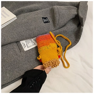 Détail d'un mini sac crocheté à la main avec rayures arc-en-ciel et texture en laine