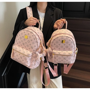 Pink monogram backpack with letter print, flower pattern, and a cute teddy bear charm