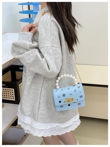Piccola borsa a tracolla azzurra per bambina con motivi graffiti e manico di perle