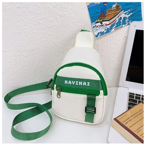 Detail view of canvas chest bag featuring green KAYINAI letter straps and metal zipper