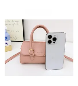 Pink mini leather handbag shown next to a smartphone for size comparison reference