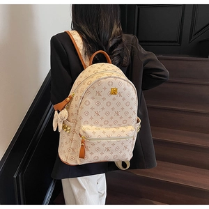 Detail view of cream leather backpack with NX monogram pattern and golden rivets