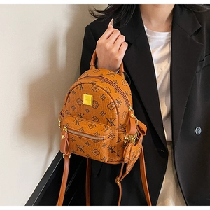 Detail of caramel monogram mini backpack with gold metal plate and elephant charm