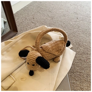 Macro detail of a handmade knitted dog-shaped shoulder bag featuring premium cotton texture