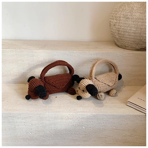 Detail of handmade knit puppy shoulder bags in brown and beige with woven texture