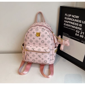 Close-up of pink fashion backpack featuring monogram print and cute bear charm detail
