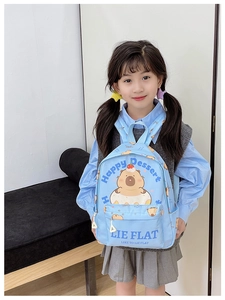 Detail of cute light blue kids backpack with cartoon capybara and donut print design