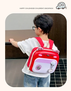 Rear view of a child wearing a cute red hardshell cat-themed backpack with ears