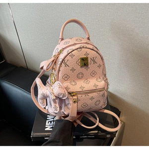 Detailed view of pink mini backpack with floral pattern and cute cat charm pendant