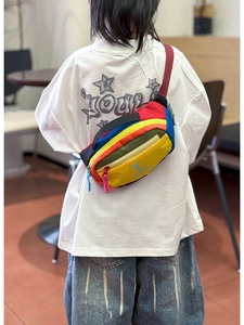 Rear view of a child wearing a colorful patchwork chest bag with adjustable red strap