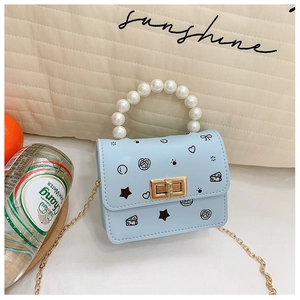 Dettaglio mini borsa azzurra con manico di perle, chiusura dorata e stampe graffiti