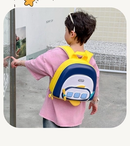 Toddler wearing a cute 3D airplane backpack with yellow wings in an outdoor setting