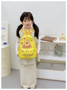 Detailed view of yellow kids backpack featuring a cute cartoon animal on a donut design