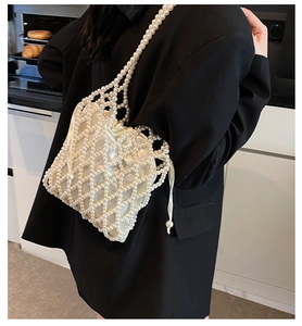 Detail of white handmade beaded shoulder bag with satin lining and pearl chain strap
