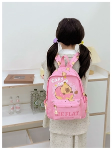 Pink kids backpack with cute Capybara print shown on a child's back in a cozy room