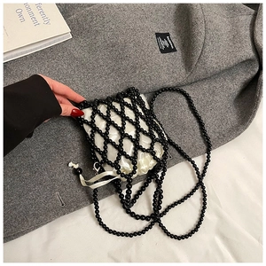 Detail of beaded mini crossbody bag with white satin drawstring liner and black pearl strap