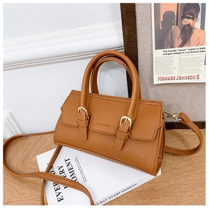 Detail of brown litchi pattern leather mini bag with golden buckles and shoulder strap