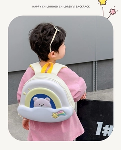 Close-up of cute white cloud backpack with bear pattern and 3D star details on a child