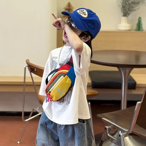 Kids colorful patchwork chest bag with blue bird logo worn by a child in a cafe