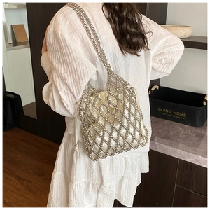 Detail of silver beaded handbag showing mesh grid texture and cream satin drawstring pouch