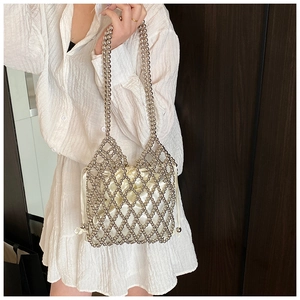 Detail of handmade silver beaded shoulder bag featuring a white satin drawstring pouch