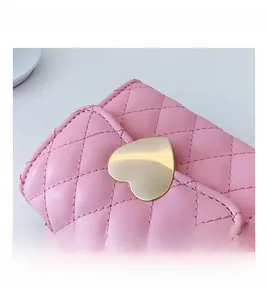 Detail of pink quilted PU leather bag featuring a gold heart buckle and chain strap