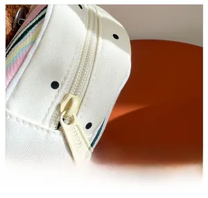 Détail d'une fermeture éclair fluide sur un sac de rangement à rayures et pois