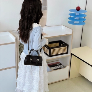 Kids black leather shoulder bag with buckle flap shown with a blue knit sweater and lace skirt