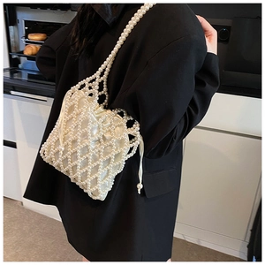 Detail of white beaded shoulder bag with satin drawstring liner and pearl mesh texture
