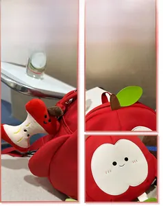 Detailansicht der roten Apfel-Stofftasche mit Plüsch-Anhänger und Blattdekor