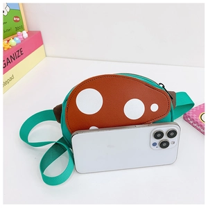Detail of mushroom crossbody bag with size comparison to a smartphone for kids