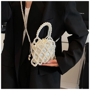 Detail of beaded white pearl handbag with silk drawstring liner on a black blazer