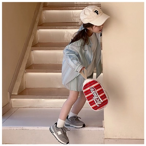 Détail d'un enfant mannequin en tenue rayée bleue avec un sac à main à rayures