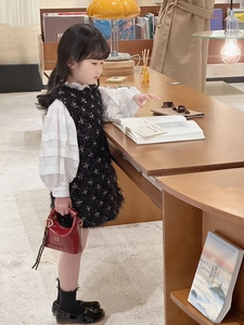 Fashionable young girl in black sequin dress and white ruffle blouse with red leather handbag