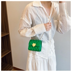 Detail of green quilted mini crossbody bag with golden heart-shaped twist lock