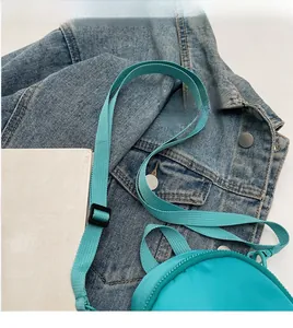 Detail of tiffany blue nylon mini crossbody bag with smooth woven long shoulder strap