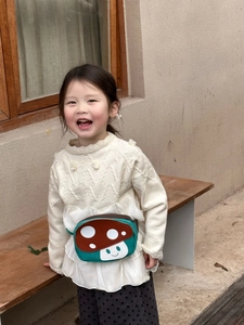 Detail of cute mushroom cartoon waist bag with adjustable strap on a child model