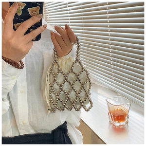 Macro detail of handmade beaded mesh handbag with silk drawstring inner lining bag