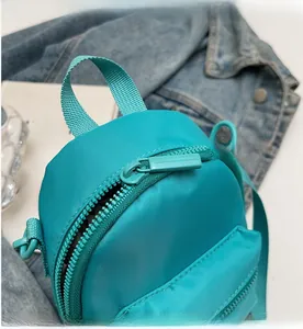 Detailed macro view of smooth zippers and durable waterproof nylon on a green mini bag