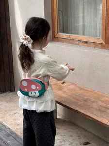 Detail view of the cute mushroom waist bag showing the adjustable green strap and zipper