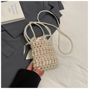 Detail view of a handmade pearl woven handbag with a soft pink silk drawstring pouch