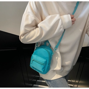 Detail of Tiffany blue mini crossbody bag with nylon texture and zippered front pocket