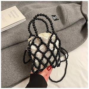 Detail of black beaded handbag featuring a satin drawstring pouch and hollow weave texture