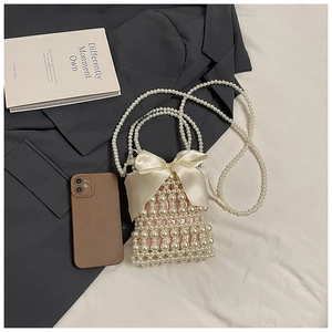 Detail of mini pearl woven bag featuring a large satin bow and pink satin lining