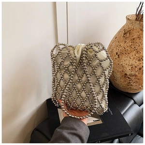 Close-up of a silver beaded bucket bag with a white satin drawstring lining