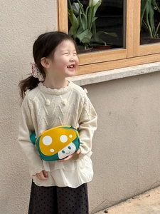 Detail of cute mushroom crossbody bag for kids with yellow top and green base strap