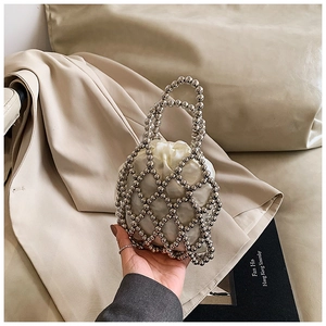 Detail of silver beaded hollow handbag with satin drawstring pouch and metal grid texture