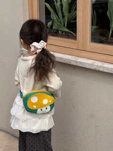Detailed outdoor shot of a cute mushroom waist bag with polka dots for kids